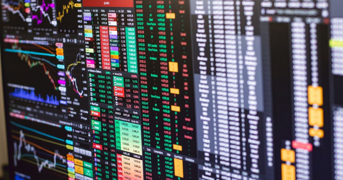 Financial trading terminal screens showing dense market data, charts and quotes