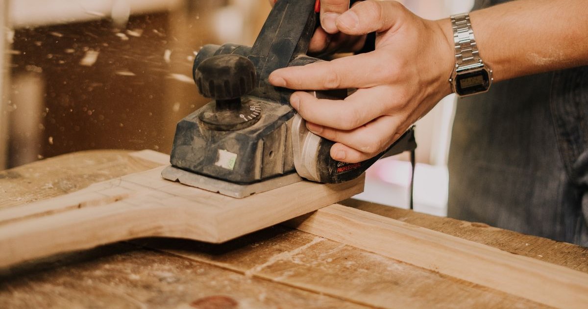 Woodworker planing a board in a home workshop